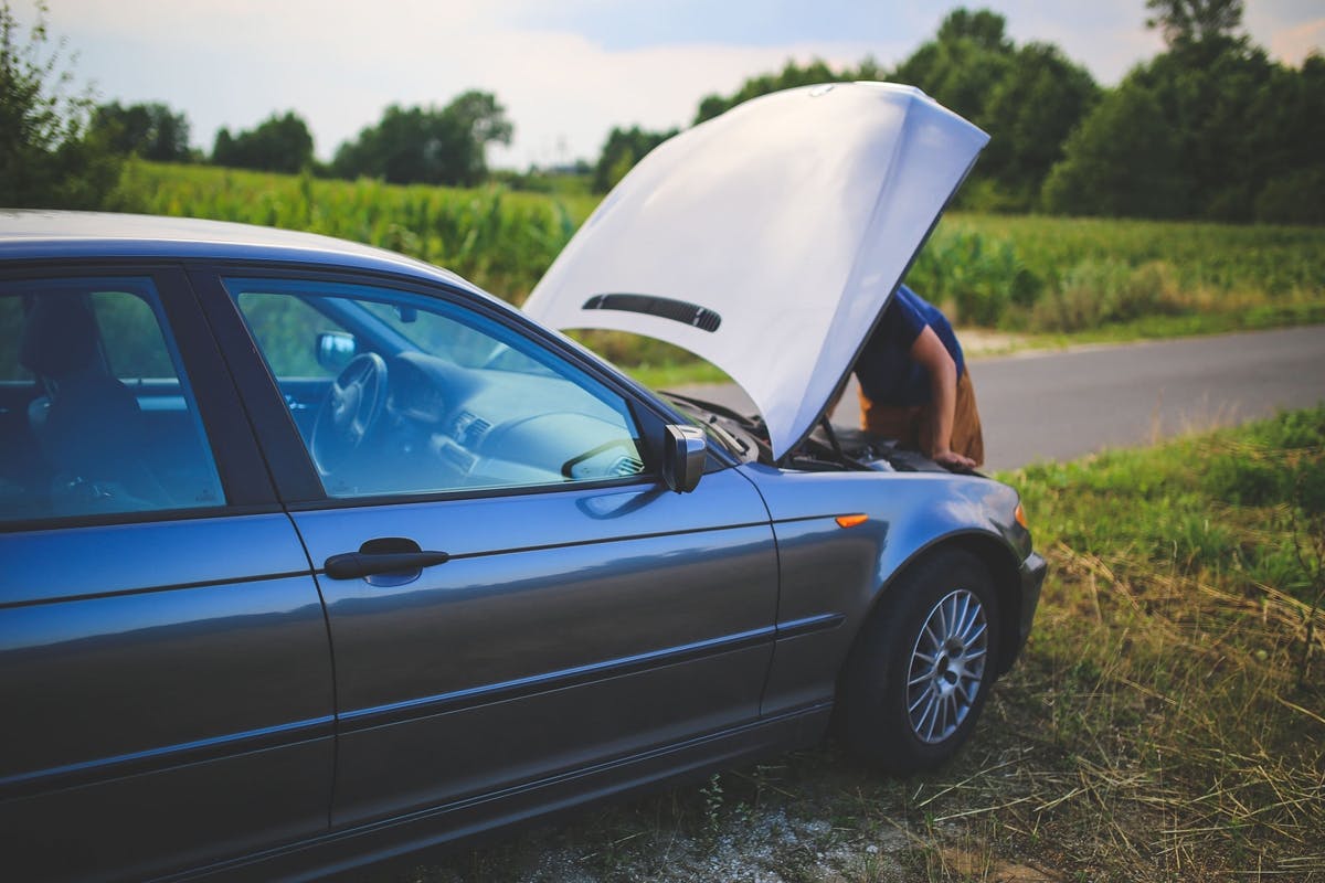 Person leder efter fejl under motorhjelmen.